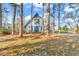 Charming home with a blue door framed by tall trees and a beautifully landscaped front yard at 1800 Glenns Bay Rd., Surfside Beach, SC 29575