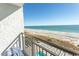 Scenic balcony overlooking a serene beach with clear blue skies, providing an ideal spot for enjoying the ocean breeze at 2001 S Ocean Blvd. # 405, Myrtle Beach, SC 29577