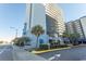 Street view of the Bluewater condo building surrounded by palm trees with well-maintained landscaping and a clear view of the signage at 2001 S Ocean Blvd. # 405, Myrtle Beach, SC 29577