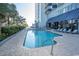 Refreshing outdoor pool with a net, surrounded by chairs and greenery, perfect for swimming and relaxing in a tropical setting at 2001 S Ocean Blvd. # 405, Myrtle Beach, SC 29577