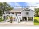 Charming gray beach house on stilts with white railings and a welcoming staircase entrance at 202 Old Harbour Ct., Little River, SC 29566