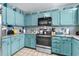 Bright kitchen with stainless steel appliances, aqua blue cabinets, and mosaic backsplash at 202 Old Harbour Ct., Little River, SC 29566