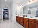 Bathroom featuring double vanity sinks with dark wood cabinets and walk-in closet at 2051 Lindrick Ct., Calabash, NC 28467