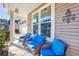 Inviting front porch featuring comfortable seating with wicker chairs and blue cushions at 2051 Lindrick Ct., Calabash, NC 28467