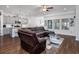 Open-concept living room with a large leather sectional, wood floors, and lots of natural light at 2051 Lindrick Ct., Calabash, NC 28467