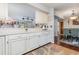 Bright kitchen with white cabinets, bar seating, and view to dining area with hardwood flooring at 2270 Vereen Circle, Little River, SC 29566