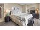 Bedroom with neutral color scheme, side table with lamp, wooden dresser and hardwood floors at 2301 S Ocean Blvd. # 1401, North Myrtle Beach, SC 29582