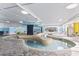 Indoor pool with multiple water sections surrounded by a tiled floor and varying lounge chairs, with decorative lighting overhead at 2301 S Ocean Blvd. # 1401, North Myrtle Beach, SC 29582