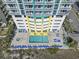 Overhead view of complex pool and hot tub, with lounge chairs, tables and umbrellas at the base of the condo building at 2301 S Ocean Blvd. # 1401, North Myrtle Beach, SC 29582