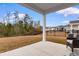 Relaxing backyard patio with views of the lawn, trees, and neighboring houses beyond the black metal fence at 242 Timber Oaks Dr., Myrtle Beach, SC 29588