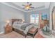 A spacious bedroom features a tray ceiling, ceiling fan, carpet, a large window, and a dresser with a TV at 256 Maple Oak Dr., Conway, SC 29526