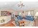 Spacious living room with comfortable blue couches, a ceiling fan, and an open layout at 256 Maple Oak Dr., Conway, SC 29526