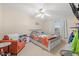 Sunlit bedroom with a ceiling fan, coral patterned quilt, and comfortable sitting area at 287 Kanawha Trail, Longs, SC 29568