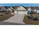 Aerial shot of a home with a long driveway, two car garage, and meticulously landscaped front yard at 302 Camrose Way, Myrtle Beach, SC 29588