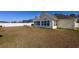 Large backyard featuring screened porch with view of white fence and house exterior at 302 Camrose Way, Myrtle Beach, SC 29588