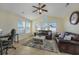 Bright living room featuring comfortable leather couches, a ceiling fan, and large windows at 302 Camrose Way, Myrtle Beach, SC 29588