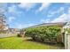 A lush backyard features green grass, verdant bushes, and a partial view of the home's brick exterior at 3791 Cagney Ln., Myrtle Beach, SC 29577