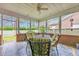 Relaxing screened porch with ceiling fan, tile floors, and ornamental metal table with seating at 3791 Cagney Ln., Myrtle Beach, SC 29577