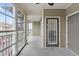 View of the screened-in porch with neutral siding and storm door to the right of the image at 395 S Crow Creek Dr. # 1418, Calabash, NC 28467