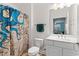 Bright bathroom featuring a single sink vanity and a shower with a nautical-themed curtain at 395 S Crow Creek Dr. # 1418, Calabash, NC 28467