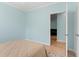 Bright bedroom featuring light blue walls, wood flooring, and an open doorway to the living room at 395 S Crow Creek Dr. # 1418, Calabash, NC 28467