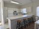 Open kitchen with white cabinets, breakfast bar, and view into the dining area at 3955 Gladiola Ct. # 301, Myrtle Beach, SC 29588