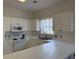Well-lit kitchen with white cabinets, stainless steel sink, and ample counter space at 3955 Gladiola Ct. # 301, Myrtle Beach, SC 29588