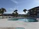 Community pool surrounded by palm trees and white fencing with lounge chairs for relaxing at 3955 Gladiola Ct. # 301, Myrtle Beach, SC 29588