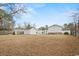 Exterior view of backyard featuring outbuildings and an expansive grassy lawn at 410 Martin St., Mullins, SC 29574