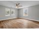 Bright bedroom features hardwood flooring, fresh paint, and natural light from the three windows at 410 Martin St., Mullins, SC 29574