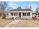 Charming home featuring a cozy front porch with classic white railings and brick accents at 410 Martin St., Mullins, SC 29574