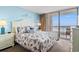 Bedroom featuring large bed with ensuite bathroom and sliding glass door to a balcony with ocean views at 4111 Ocean Blvd. S # 402, North Myrtle Beach, SC 29582