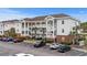 Three-story condo with a parking lot and palm trees at 4140 Hibiscus Dr. # 303, Little River, SC 29566