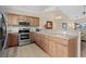 Spacious kitchen showcasing stainless steel appliances, wooden cabinets, and tile flooring at 4140 Hibiscus Dr. # 303, Little River, SC 29566