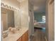 Bathroom featuring a double sink vanity with light wood cabinets, large mirror and view into the bedroom at 4220 Coquina Harbour Dr. # B-12, Little River, SC 29566