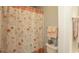 Bathroom showing a toilet and floral shower curtain with various decorative accents and neutral colored walls at 4220 Coquina Harbour Dr. # B-12, Little River, SC 29566