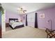 Bright bedroom with lavender walls, ceiling fan and large window with curtains at 4309 River Gate Ln., Little River, SC 29566