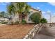 Landscaped front yard with a palm tree and stone accents on the home's exterior at 4309 River Gate Ln., Little River, SC 29566