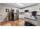 Efficient kitchen featuring white cabinets, stainless steel appliances, and hardwood floors at 4309 River Gate Ln., Little River, SC 29566