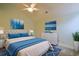 Cozy bedroom features a neutral color scheme and a large window with decorative blue-themed paintings at 48 Twelve Oaks Dr. # 2, Pawleys Island, SC 29585