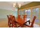 Open dining room with wooden table, chandelier, and sliding glass doors at 48 Twelve Oaks Dr. # 2, Pawleys Island, SC 29585