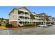 Exterior view of a multi-level condo building with private balconies and ample parking at 5751 Oyster Catcher Dr. # 633, North Myrtle Beach, SC 29582