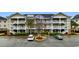 Condo building with multiple units, white railings, and lush green landscaping at 5751 Oyster Catcher Dr. # 633, North Myrtle Beach, SC 29582