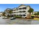 Spacious condo building featuring multiple levels, parking, and manicured landscaping at 5751 Oyster Catcher Dr. # 633, North Myrtle Beach, SC 29582