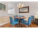 Charming dining area featuring a round wood table, blue chairs, and a chandelier at 5751 Oyster Catcher Dr. # 633, North Myrtle Beach, SC 29582