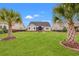 Well-manicured backyard with a spacious lawn, palm trees, and an inviting gazebo at 641 Indigo Bay Circle, Myrtle Beach, SC 29579