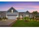 Charming home with manicured lawn, a pergola over the garage, and delightful landscaping illuminated at twilight at 641 Indigo Bay Circle, Myrtle Beach, SC 29579