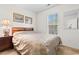 Comfortable bedroom with neutral carpet, a large window, and a queen bed featuring a decorative headboard and matching nightstand at 6494 Royal Pine Dr., Myrtle Beach, SC 29588