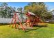 Community playground featuring a wooden play structure, swings, and a slide, perfect for Gathering fun at 6494 Royal Pine Dr., Myrtle Beach, SC 29588