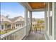 Balcony with wood floors, white railing, table and chairs and views of other homes in the neighborhood at 8035 Arcady St. # B, Myrtle Beach, SC 29572